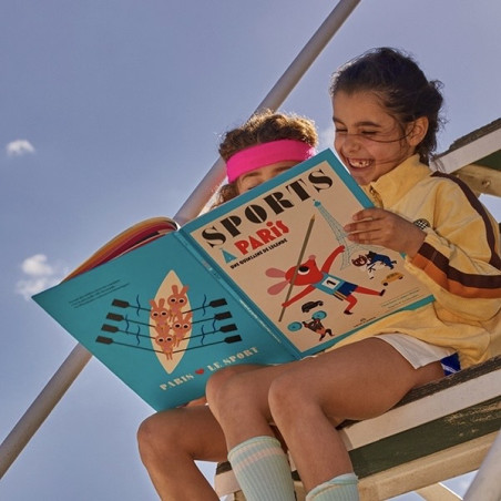 deux enfants qui lisent le Livre "Sport à paris"