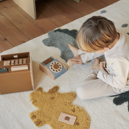 enfant qui joue avec le téléphone dans une chambre